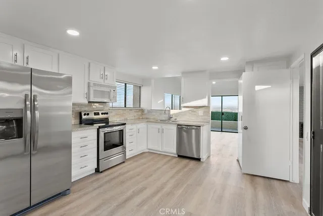 a kitchen with a refrigerator sink and cabinets
