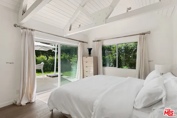 a bedroom with a bed and a large window with outer view