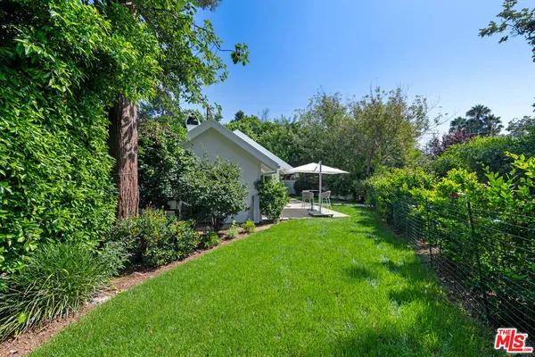 a view of a house with a yard and potted plants