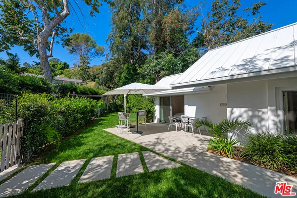 a view of a patio with a table and chairs under an umbrella