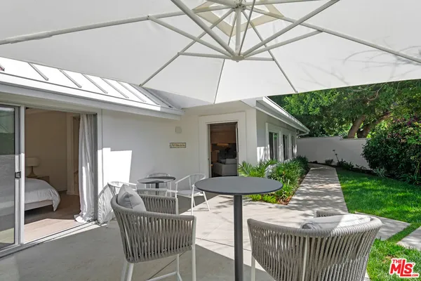 a patio with a table and chairs and a barbeque