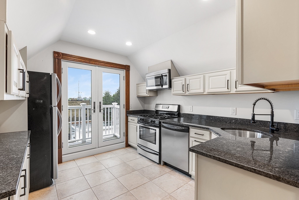 a kitchen with stainless steel appliances granite countertop a stove sink and cabinets