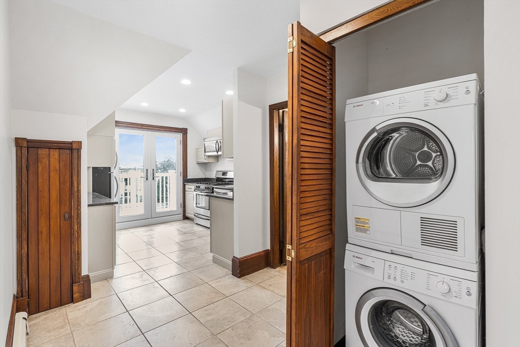 280 Broadway, Unit 5 Somerville, MA 02145 - Photo 3 of 13 a view of a kitchen with refrigerator and cabinets