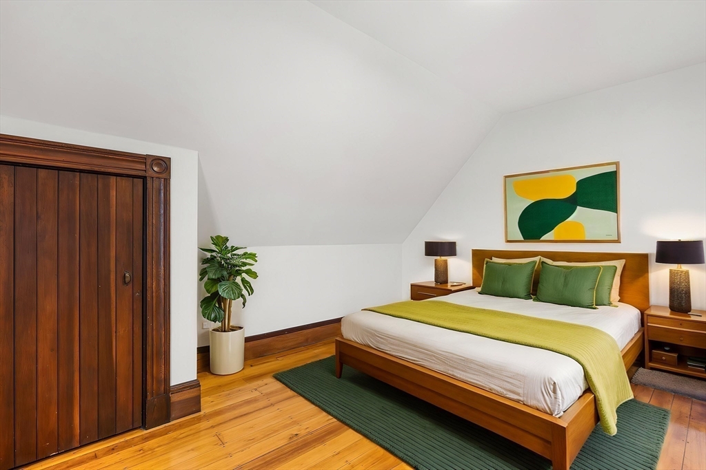 280 Broadway, Unit 5 Somerville, MA 02145 - Photo 8 of 13 a bedroom with a bed and a potted plant