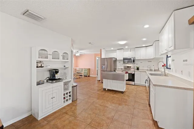 a kitchen with stainless steel appliances kitchen island granite countertop a refrigerator sink and cabinets