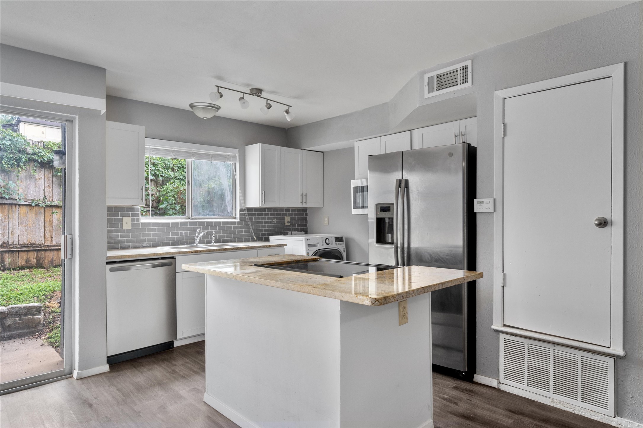 3415 Menchaca Road, Unit 113 Austin, TX 78704 - Photo 5 of 21 a kitchen with kitchen island a sink stainless steel appliances and window
