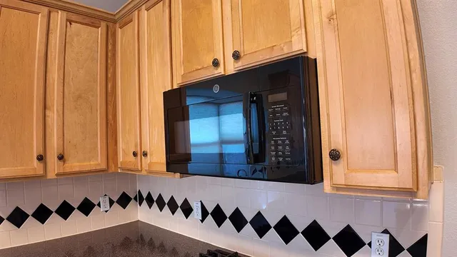 a kitchen with granite countertop a sink a stove and cabinets