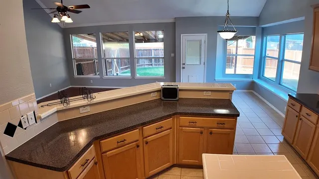 an empty room with wooden floor cabinet and ceiling fan