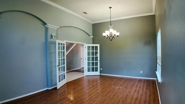 a view of a livingroom with wooden floor and a chandelier