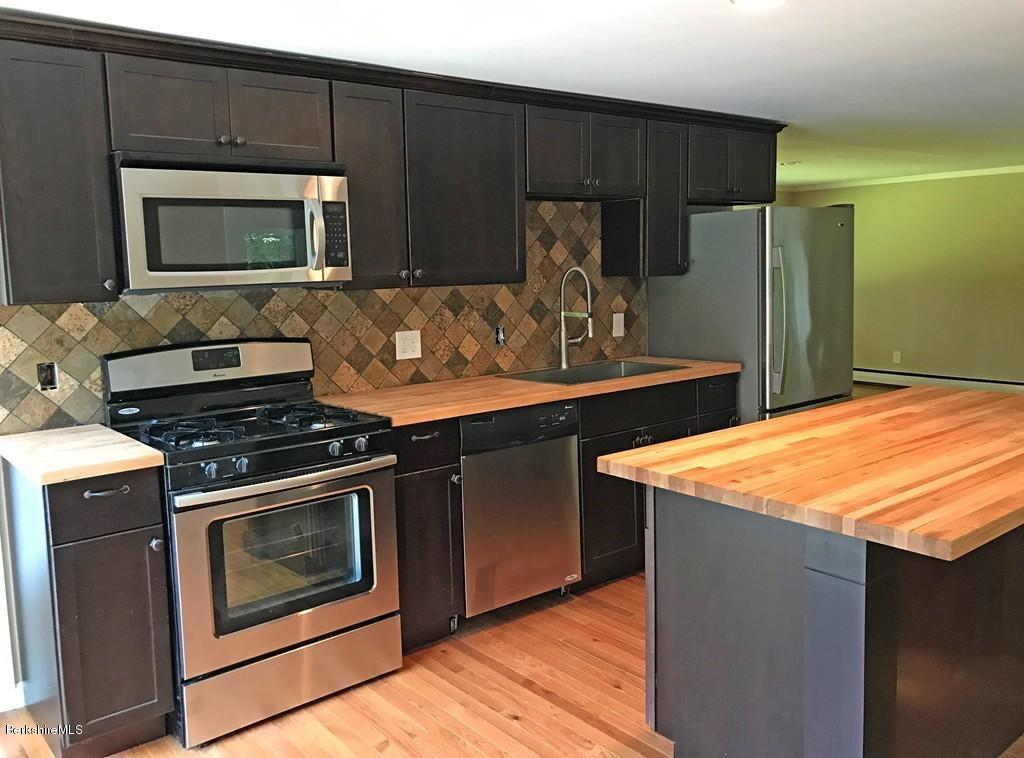 122 Davenport Road Rowe, MA 01367 - Photo 3 of 22 a kitchen with stainless steel appliances kitchen island a stove a sink and a microwave