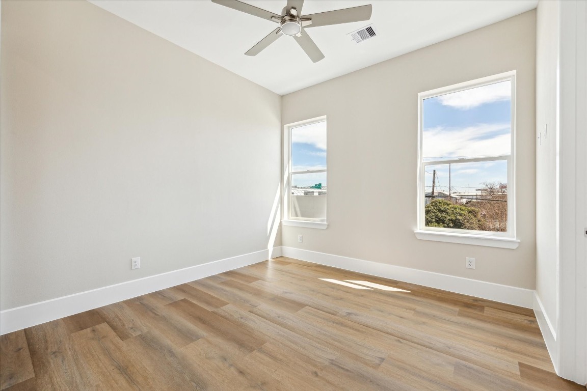 5613 Leonard Street Houston, TX 77023 - Photo 11 of 21 an empty room with wooden floor fan and windows