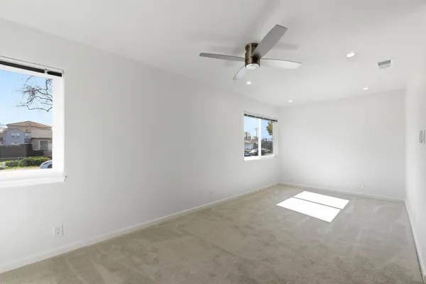 an empty room with a window and a ceiling fan