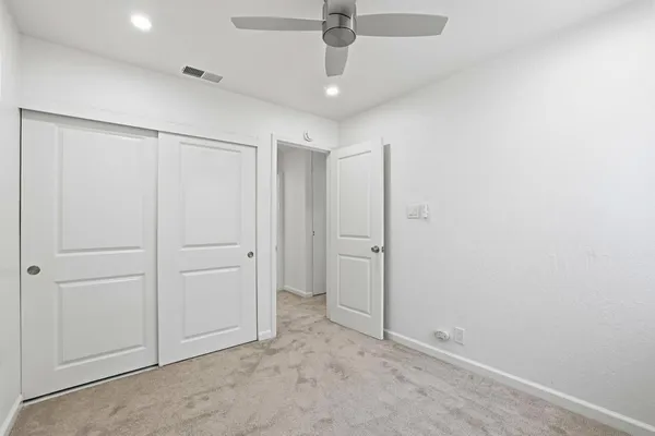 an empty room with chandelier fan