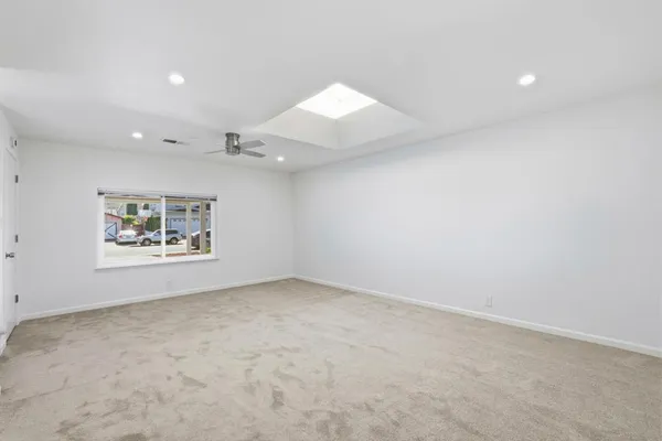 an empty room with windows and fan