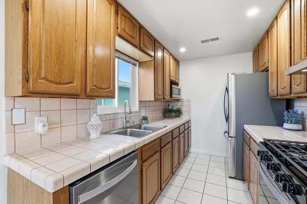 a kitchen with stainless steel appliances granite countertop a sink stove and refrigerator