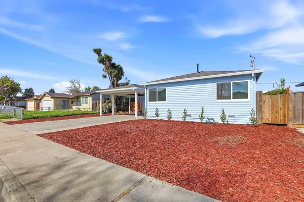 a view of a pathway of a house with wooden fence
