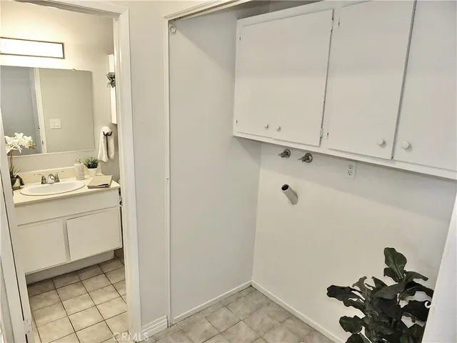 a room with white cabinets and clock on the wall