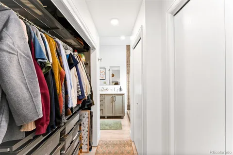 a view of walk in closet with clothes and shoes