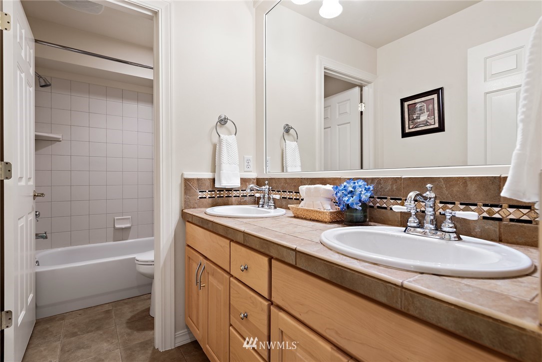18416 Southeast 195th Place Renton, WA 98058 - Photo 26 of 32 a bathroom with a granite countertop sink mirror and bathtub