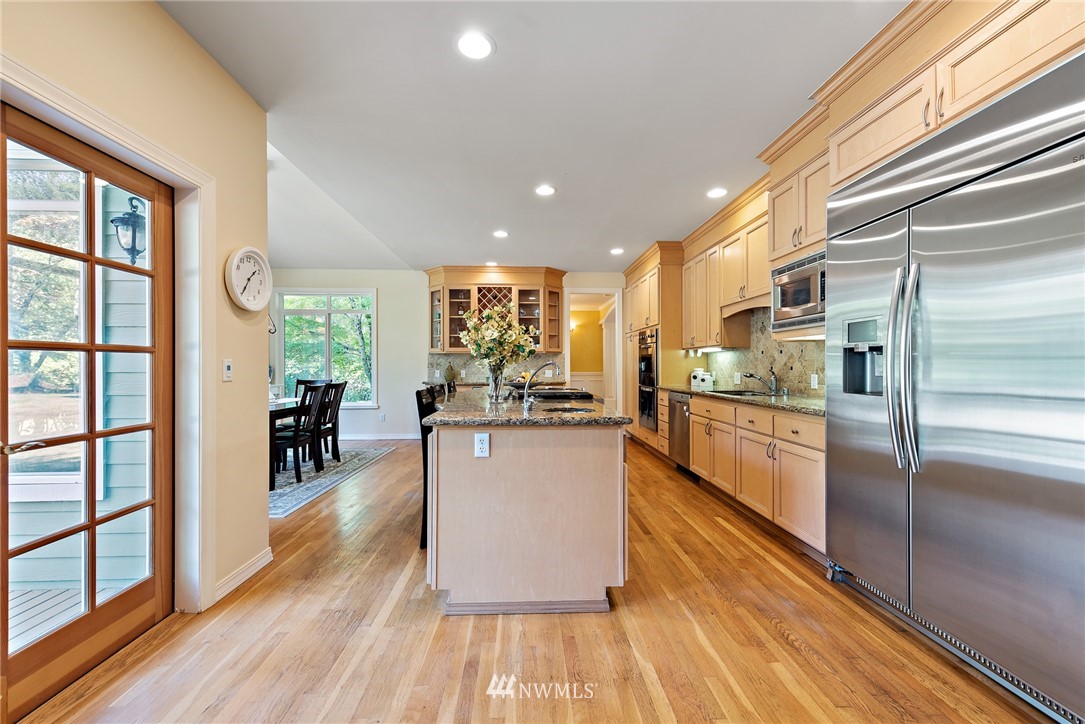 18416 Southeast 195th Place Renton, WA 98058 - Photo 8 of 32 a kitchen with stainless steel appliances granite countertop a refrigerator a oven a stove and a wooden floors