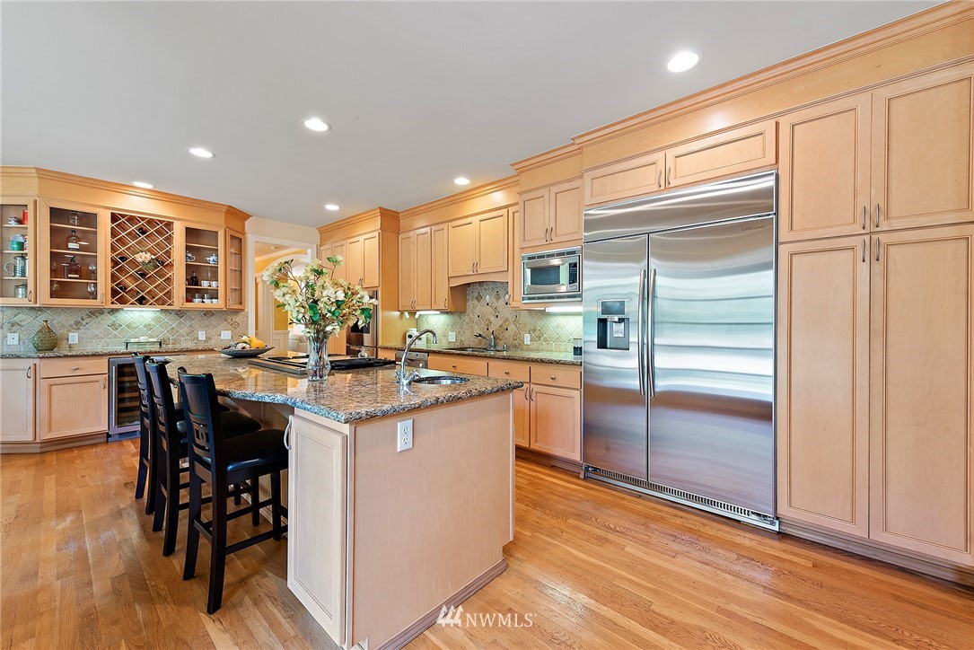 18416 Southeast 195th Place Renton, WA 98058 - Photo 9 of 32 a kitchen with kitchen island granite countertop wooden cabinets and counter space