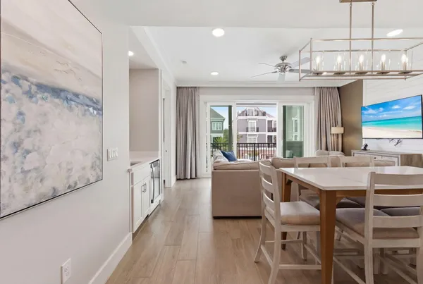 a dining hall with stainless steel appliances kitchen island granite countertop a dining table chairs and a large window