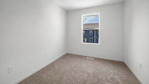 an empty room with a window and cabinet