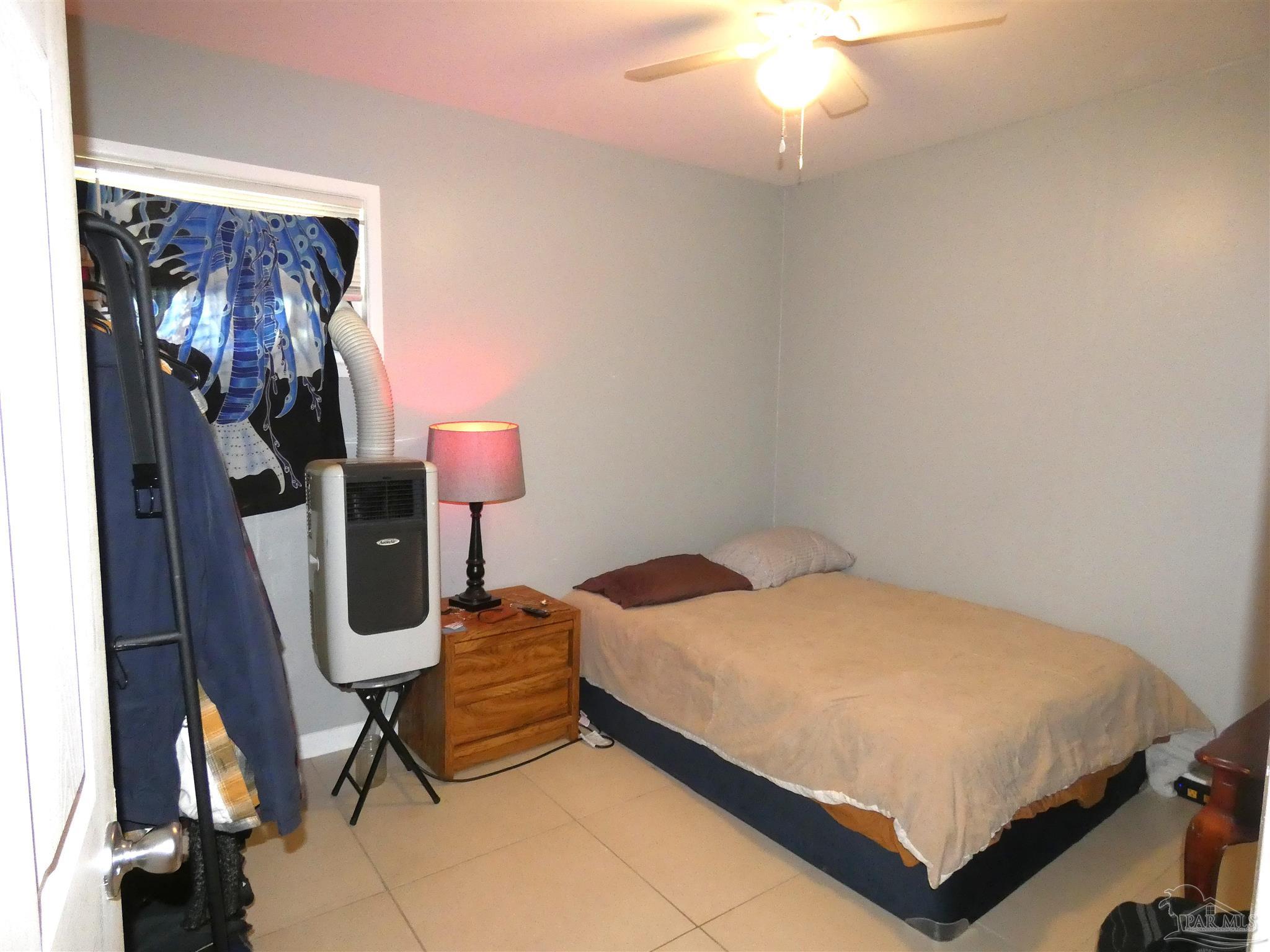 7704 West Gadsden Street Pensacola, FL 32506 - Photo 12 of 18 a bedroom with a bed and a chandelier