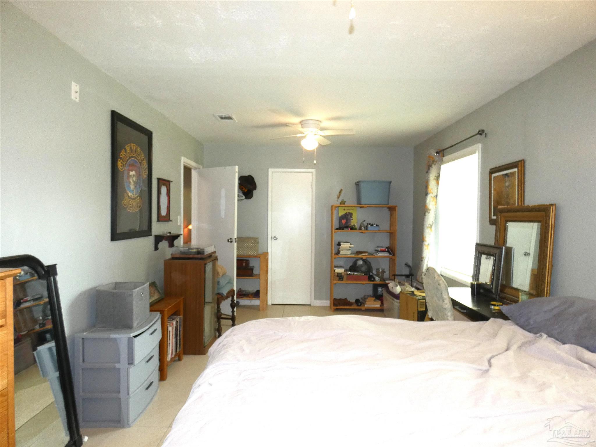 7704 West Gadsden Street Pensacola, FL 32506 - Photo 14 of 18 a bedroom with a bed and a large mirror