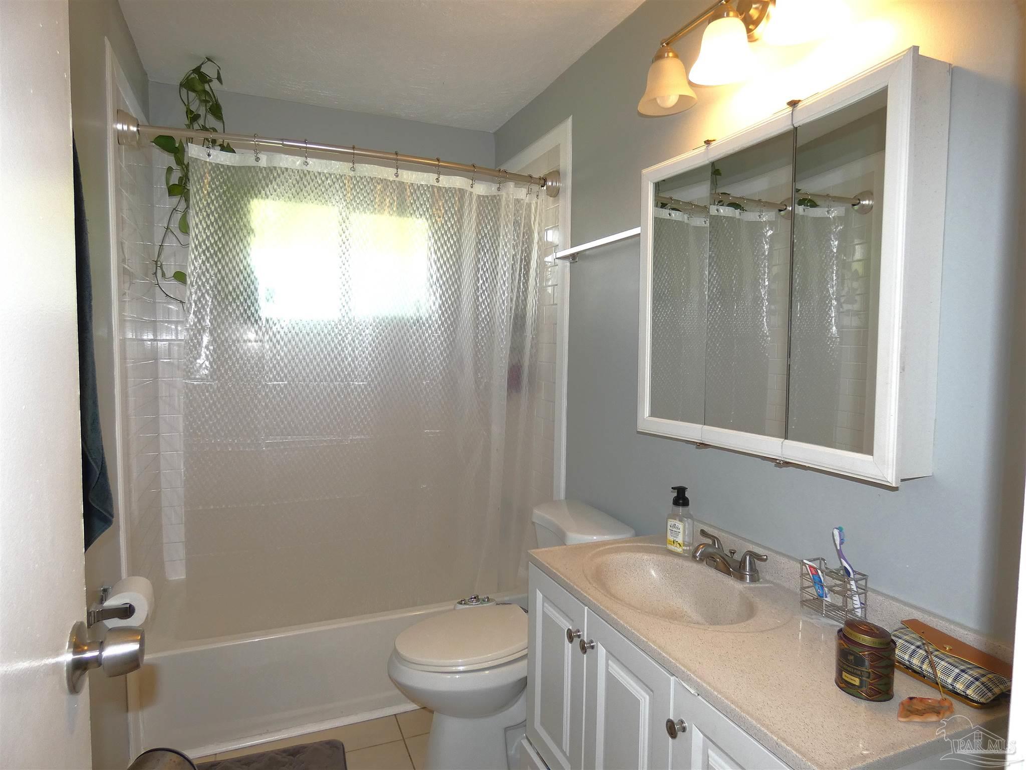 7704 West Gadsden Street Pensacola, FL 32506 - Photo 15 of 18 a bathroom with a sink toilet and shower