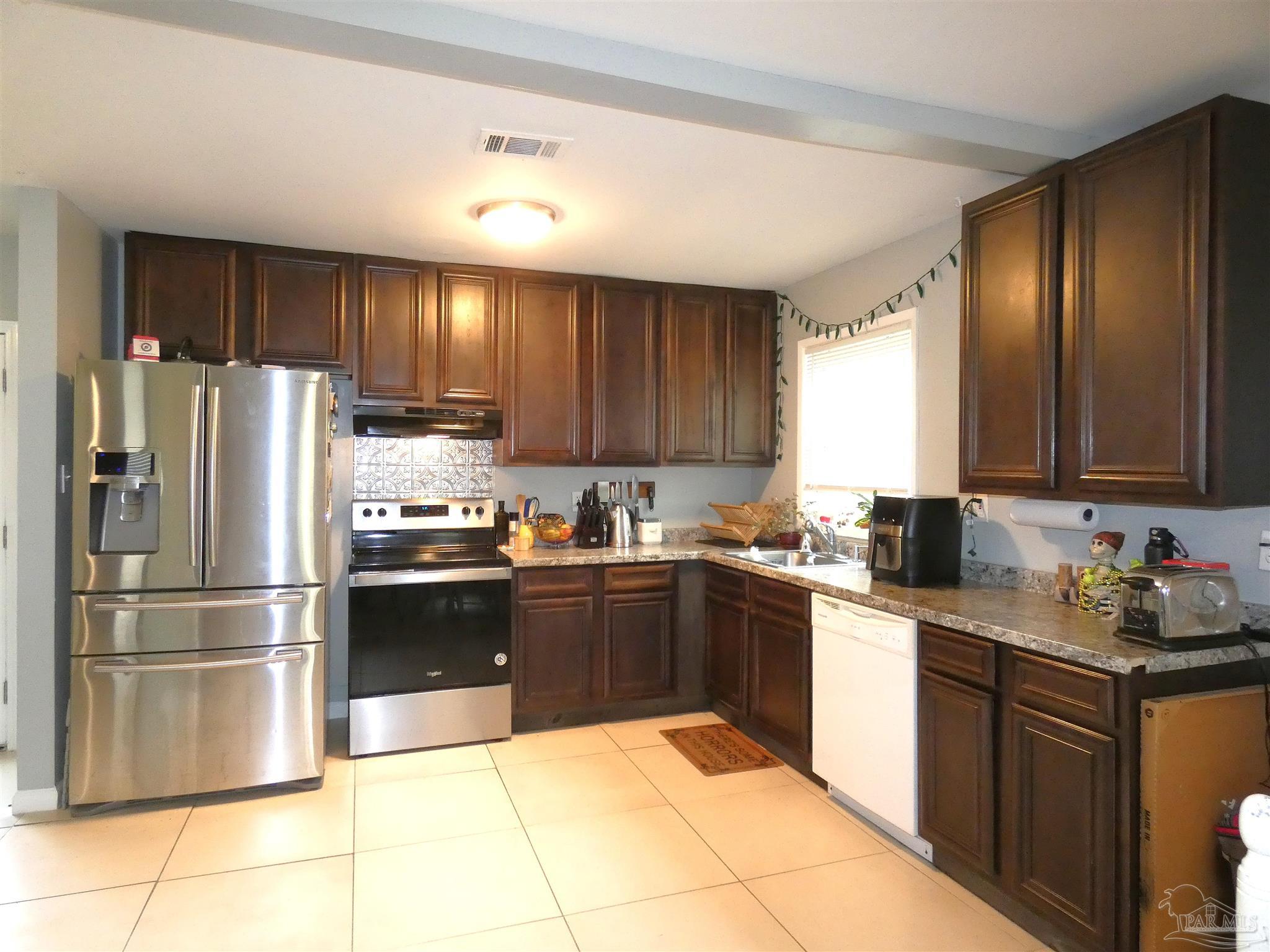 7704 West Gadsden Street Pensacola, FL 32506 - Photo 7 of 18 a kitchen with granite countertop stainless steel appliances and cabinets