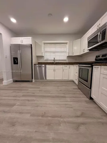 a view of kitchen with stainless steel appliances granite countertop a stove a sink and a refrigerator