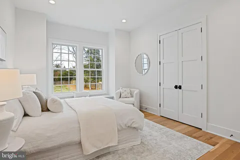 a spacious bedroom with a bed couch and a large window