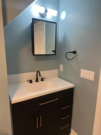 a bathroom with a sink vanity and mirror