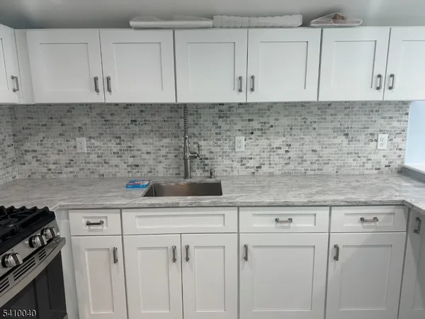 a kitchen with white cabinets and appliances