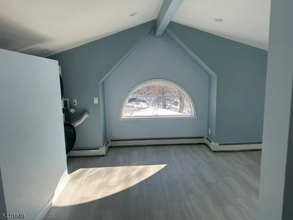 an empty room with wooden floor a ceiling fan and windows