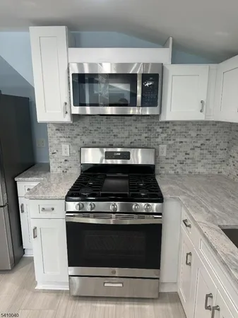 a stove top oven sitting inside of a kitchen