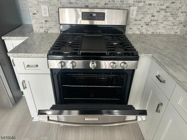 a stove top oven sitting inside of a kitchen