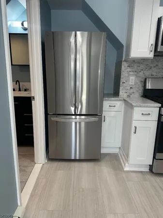 a view of a kitchen with refrigerator and cabinet
