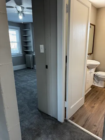 a view of a hallway with wooden floor and staircase