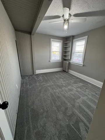 a view of a livingroom with a ceiling fan and window