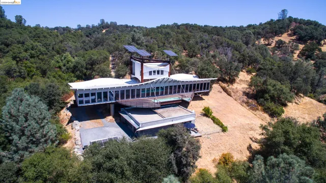 an aerial view of a house swimming pool and mountains