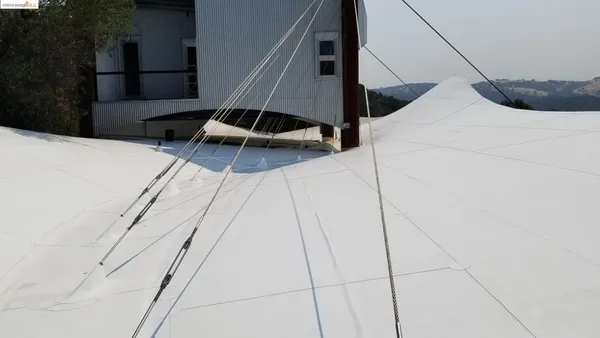 a view of a patio with table and chairs under an umbrella with wooden floor