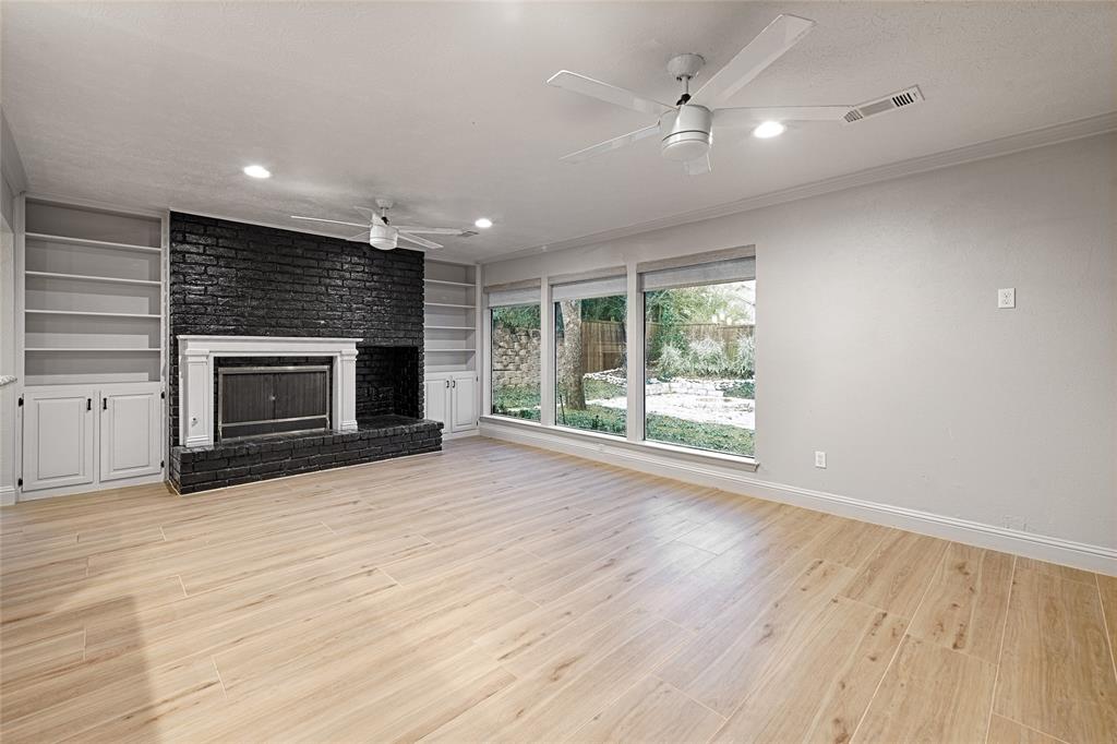 509 North Durango Circle Irving, TX 75062 - Photo 14 of 39 an empty room with fireplace wooden floor and windows