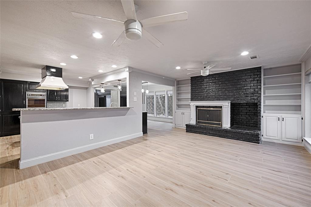 509 North Durango Circle Irving, TX 75062 - Photo 16 of 39 an empty room with wooden floor fireplace and kitchen view