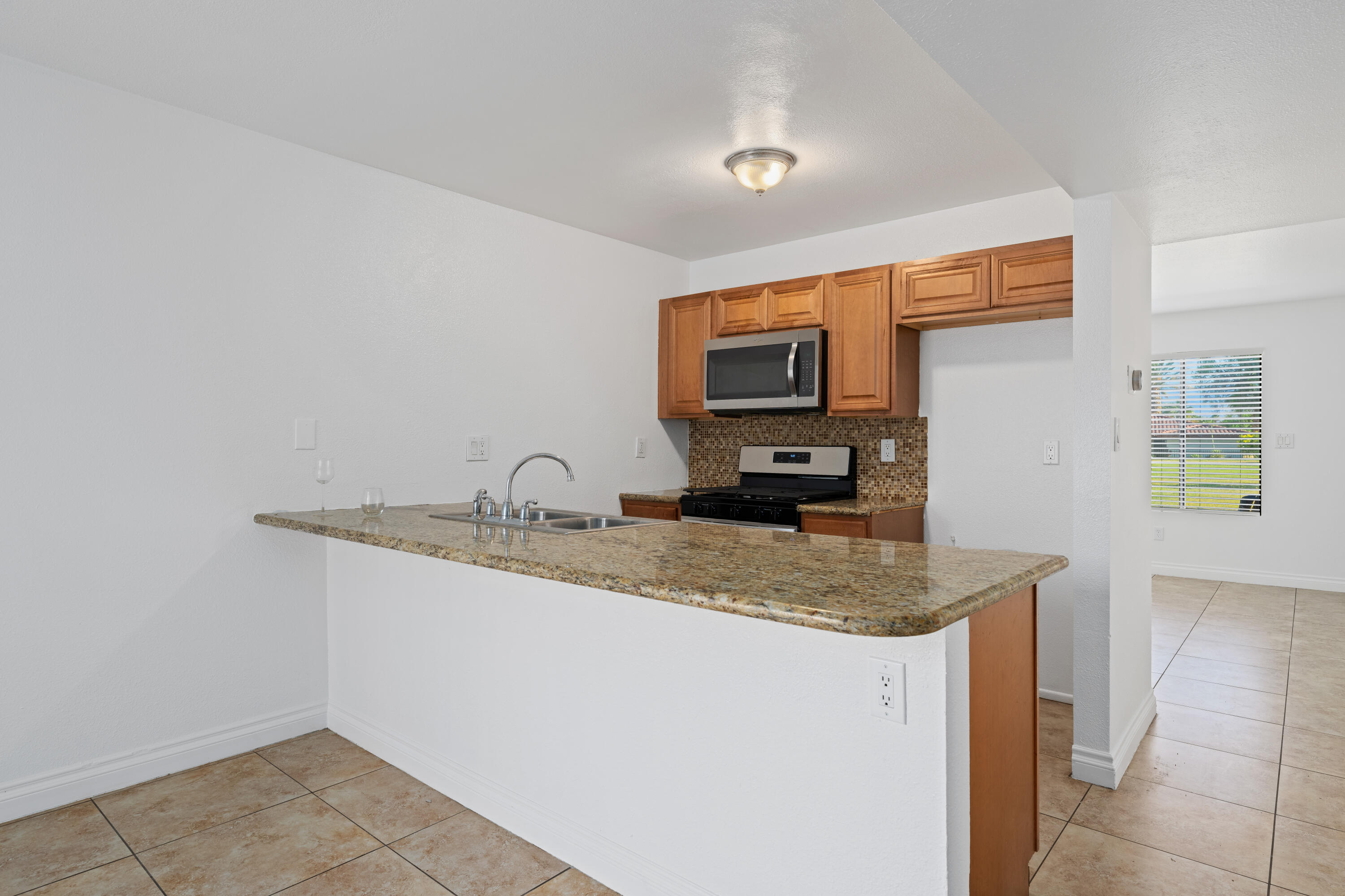 82567 Ave 48, Unit 12 Indio, CA 92201 - Photo 1 of 23 a kitchen with stainless steel appliances granite countertop a sink a stove and a refrigerator