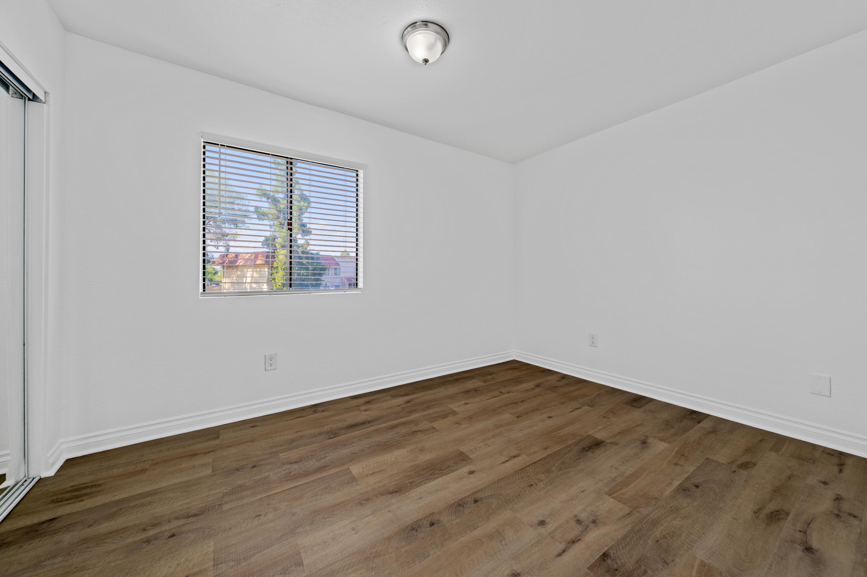 82567 Ave 48, Unit 12 Indio, CA 92201 - Photo 13 of 23 an empty room with wooden floor and windows