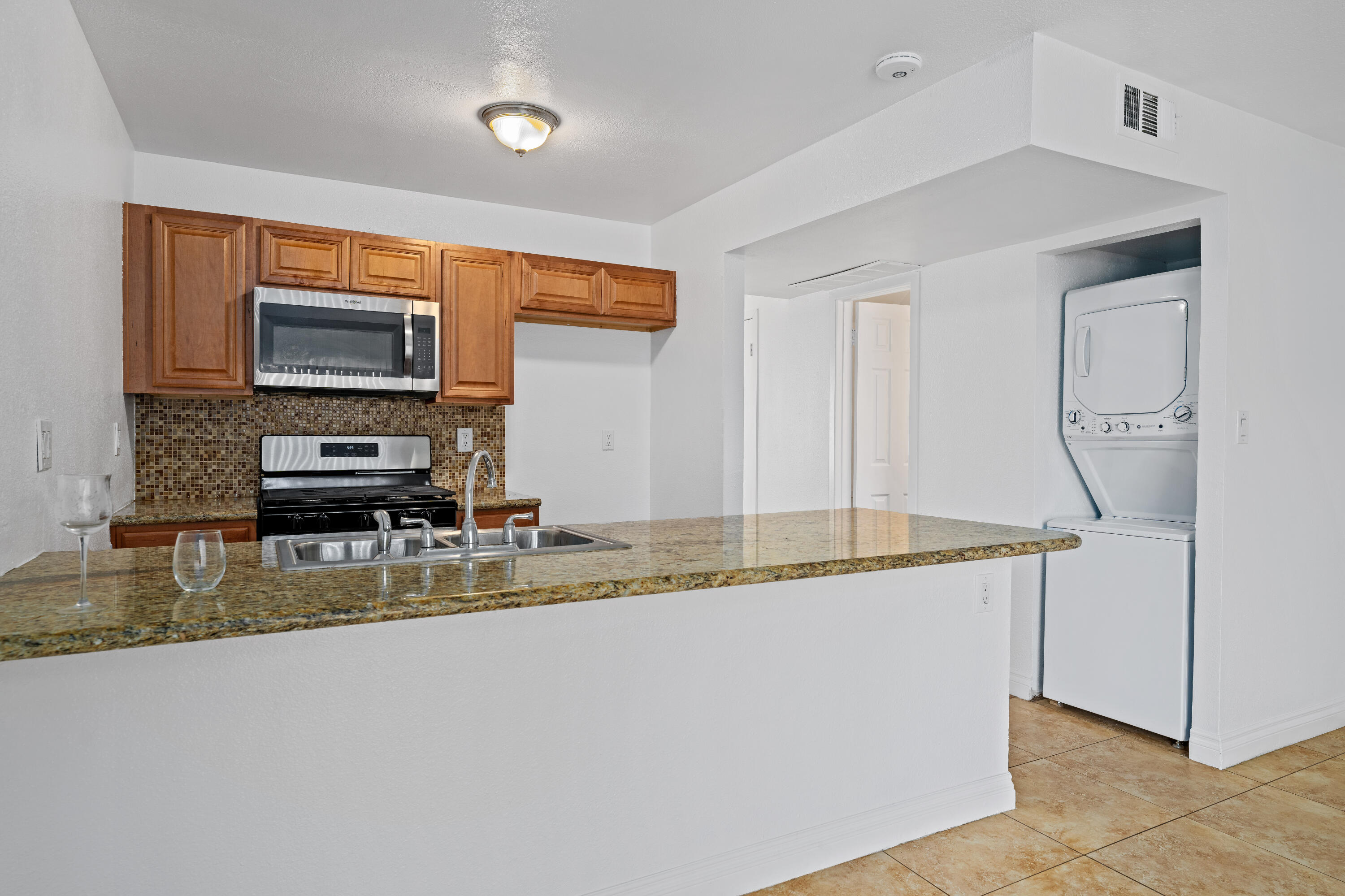 82567 Ave 48, Unit 12 Indio, CA 92201 - Photo 5 of 23 a kitchen with kitchen island granite countertop a sink a counter top space and cabinets