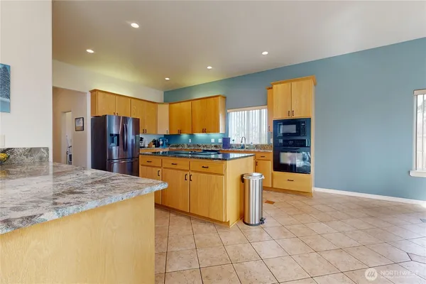 a kitchen with stainless steel appliances granite countertop a refrigerator and a sink