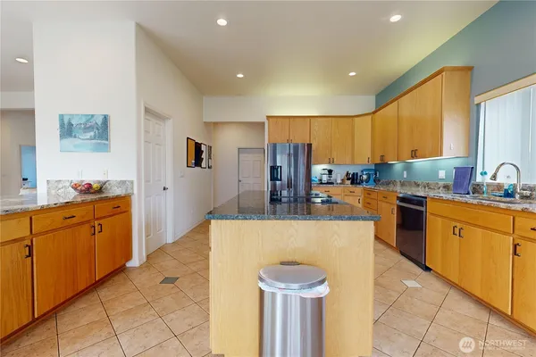a kitchen with stainless steel appliances kitchen island granite countertop a sink and cabinets